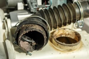 Black washing machine drain pipe with clog. The concept of proper washing machine maintenance.